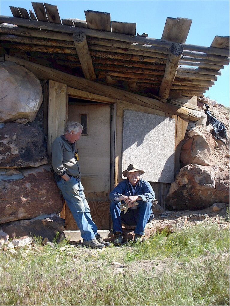 Thom and Gene sharing a story in front of the old cabin