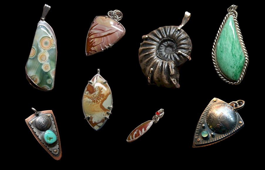 A group of pendents made from polished stones and metal work.